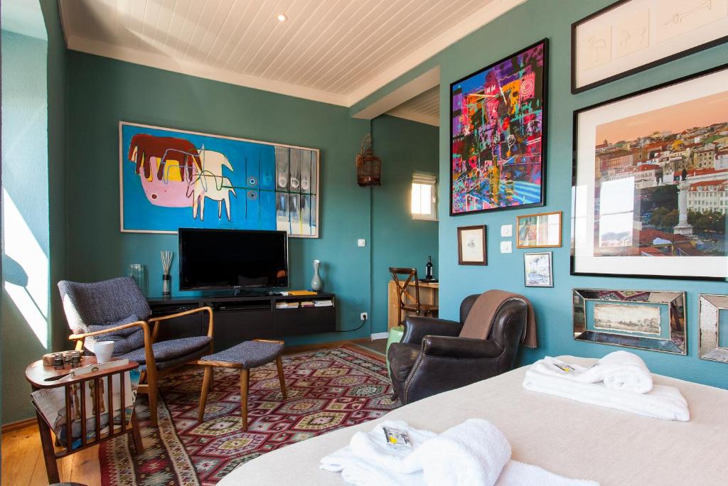 リスボンにあるALTIDO Trendy studio with views to the Castle, in Gracaのベッド2台、薄型テレビが備わるホテルルームです。