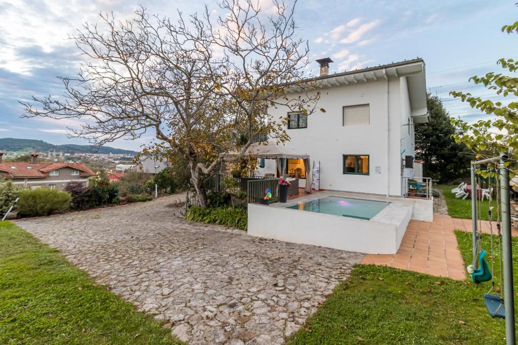a house with a swimming pool in the backyard at Casa La Quinta in Colindres