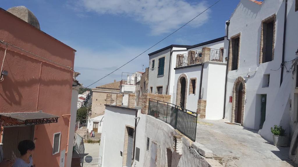 uma pessoa andando por uma rua com edifícios em B&B Alle porte di San Rocco em Pomarico