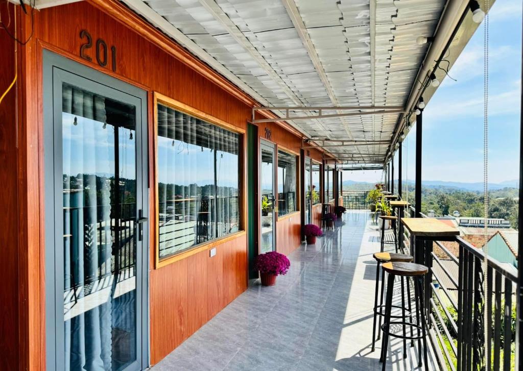 Un balcón con mesas y sillas en un edificio. en A La Mer Măng Đen, en Kon Plong