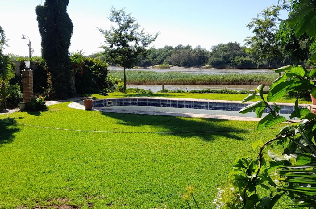 un parc avec un banc dans l'herbe dans l'établissement Budler Stay, à Upington