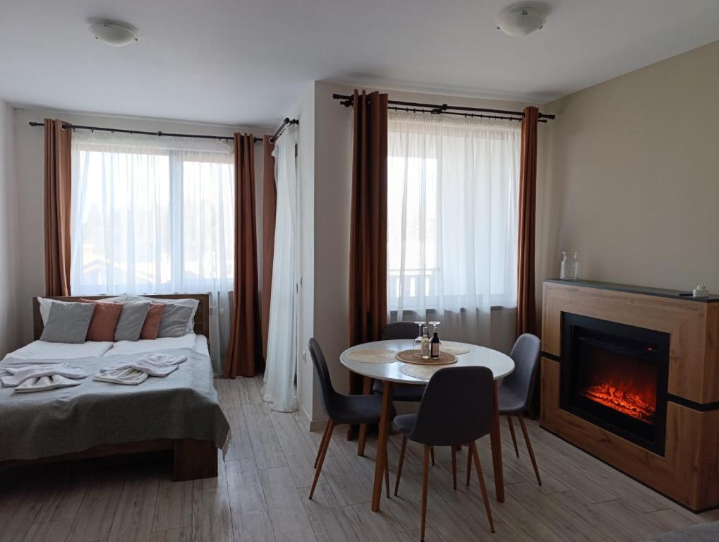 a bedroom with a bed and a table and a fireplace at Apartment B45 Borovets Gardans in Borovets