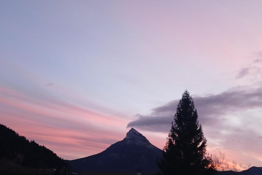 een berg met een boom voor een zonsondergang bij Les Chamoix en Chartreuse in Saint-Pierre-de-Chartreuse