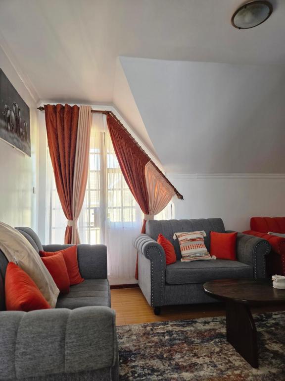 een woonkamer met twee banken en een tafel bij Homebound stays in Nairobi