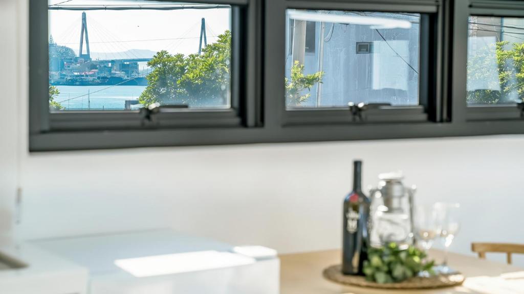 eine Küchentheke mit einem Fenster und einer Flasche Wein in der Unterkunft Yeosu Nangmanstay pension in Yeosu