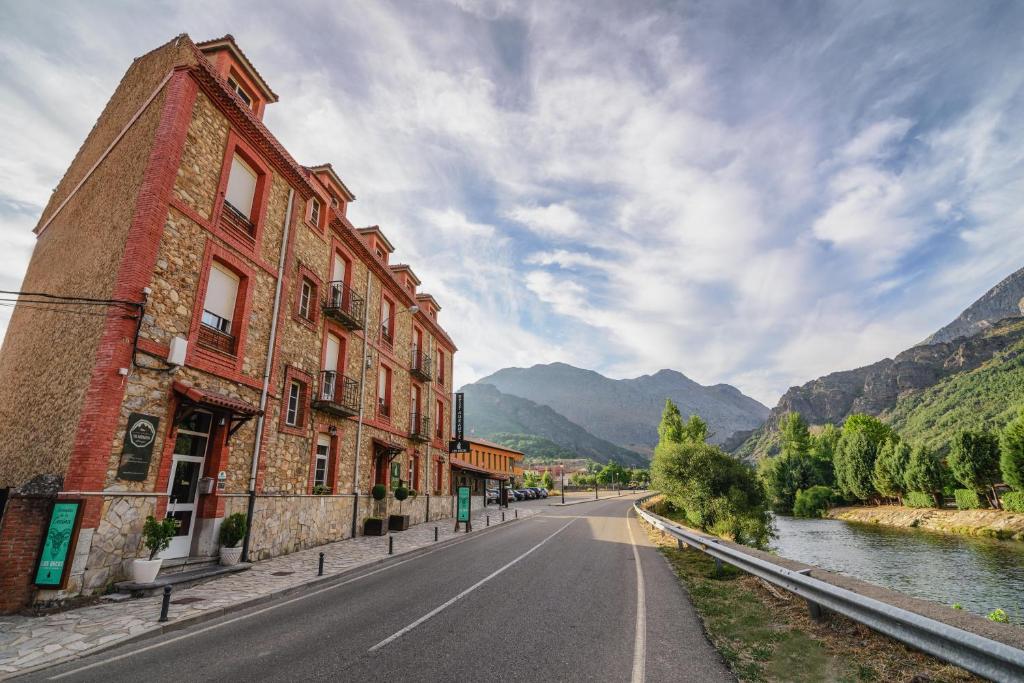 an empty street next to a building next to a river at Albergue Cueva de Valporquero in Vegacervera