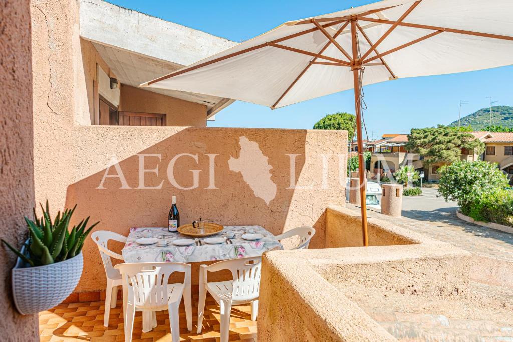 ein Tisch und Stühle und ein Sonnenschirm auf einer Terrasse in der Unterkunft Pesciolino Blu in Campese