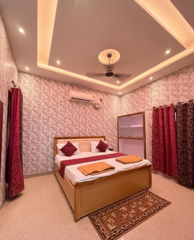 a bedroom with a bed with red curtains at Hotel Vijay Palace- Near Ram Mandir Ayodhya in Ayodhya