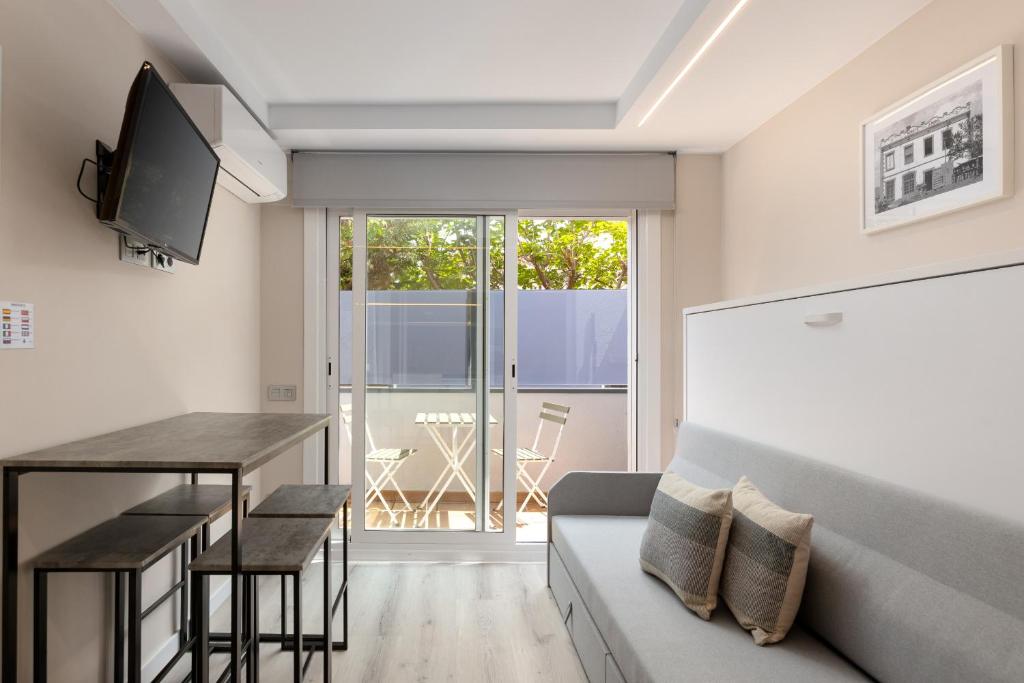 een woonkamer met een tafel en een bank bij Aparthotel Vilassar in Vilassar de Mar