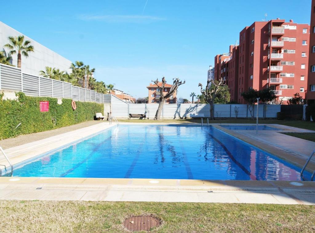 a swimming pool with blue water in a city at Rey apartment in Vilassar de Mar