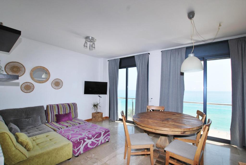 un soggiorno con un tavolo e un divano di Waves and sky a Montgat