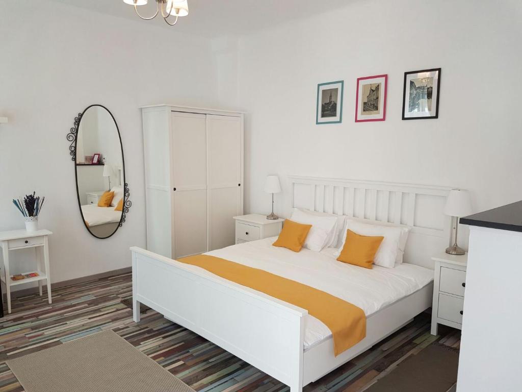 シビウにあるStudio Mai si Apartament Mai 2の白いベッドルーム(ベッド1台、鏡付)