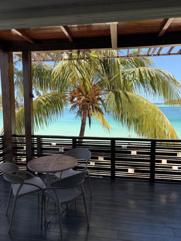 una mesa y sillas en una terraza con una palmera en Holiblue, en Blue Bay