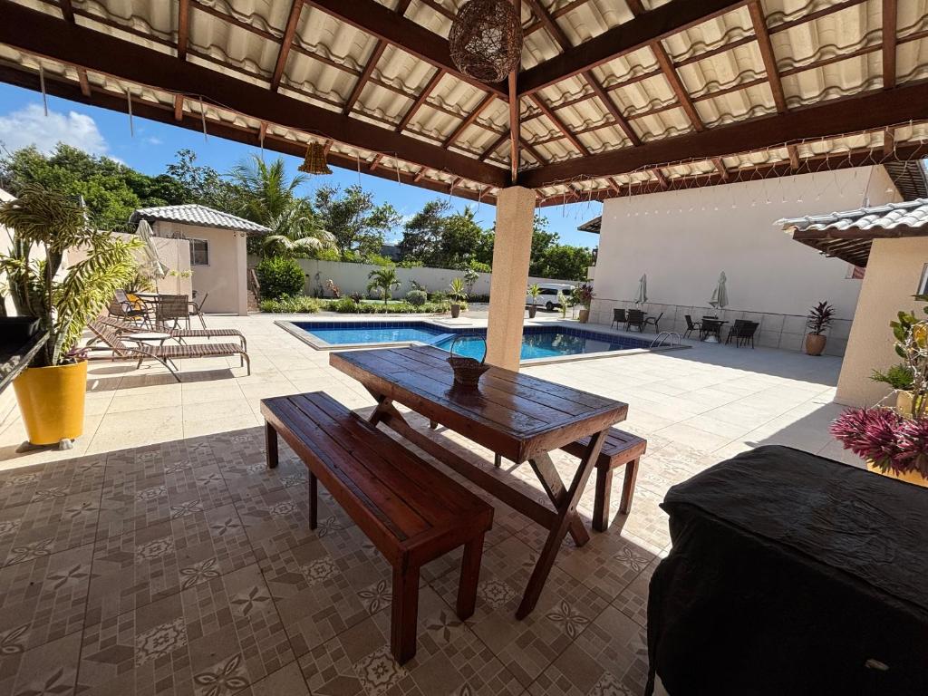 カマサリにあるChacaras do Jacuipe Villageの木製テーブルとプール付きのパティオ