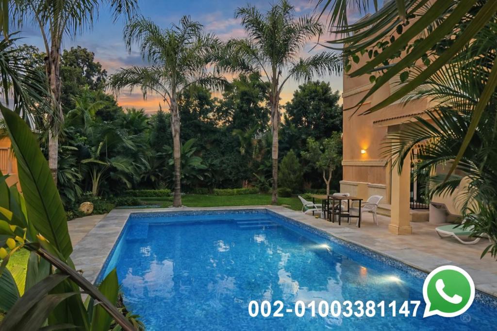 eine Villa mit Swimmingpool in einem Resort in der Unterkunft Royal Mansion with private pool in sheikh zayed Compound families in Sheikh Zayed