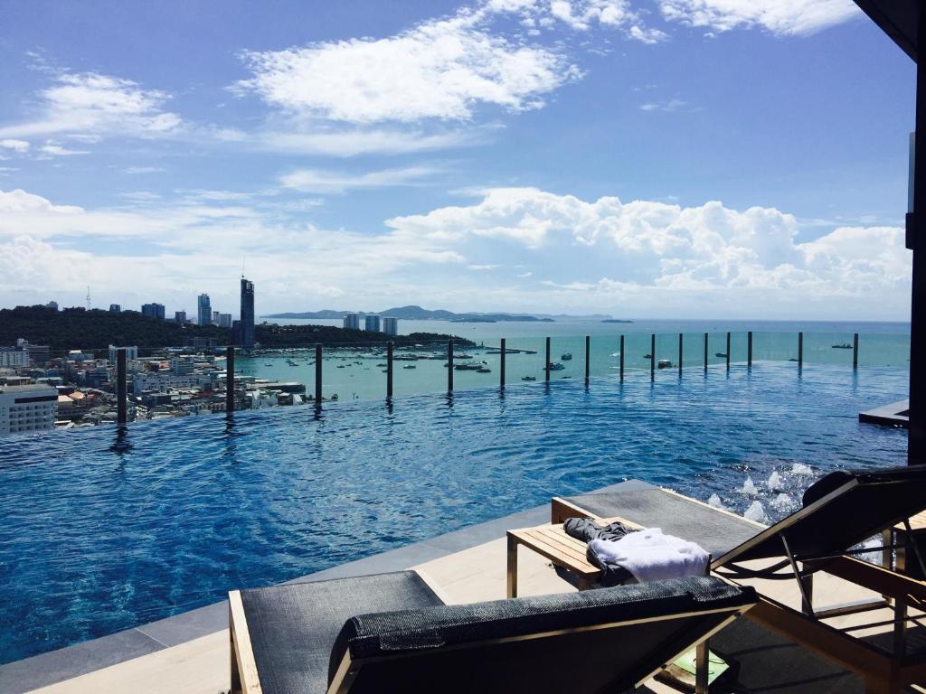 een zwembad met uitzicht op de oceaan bij Pattaya Beach Sea View Rooftop Pool Resort in Pattaya