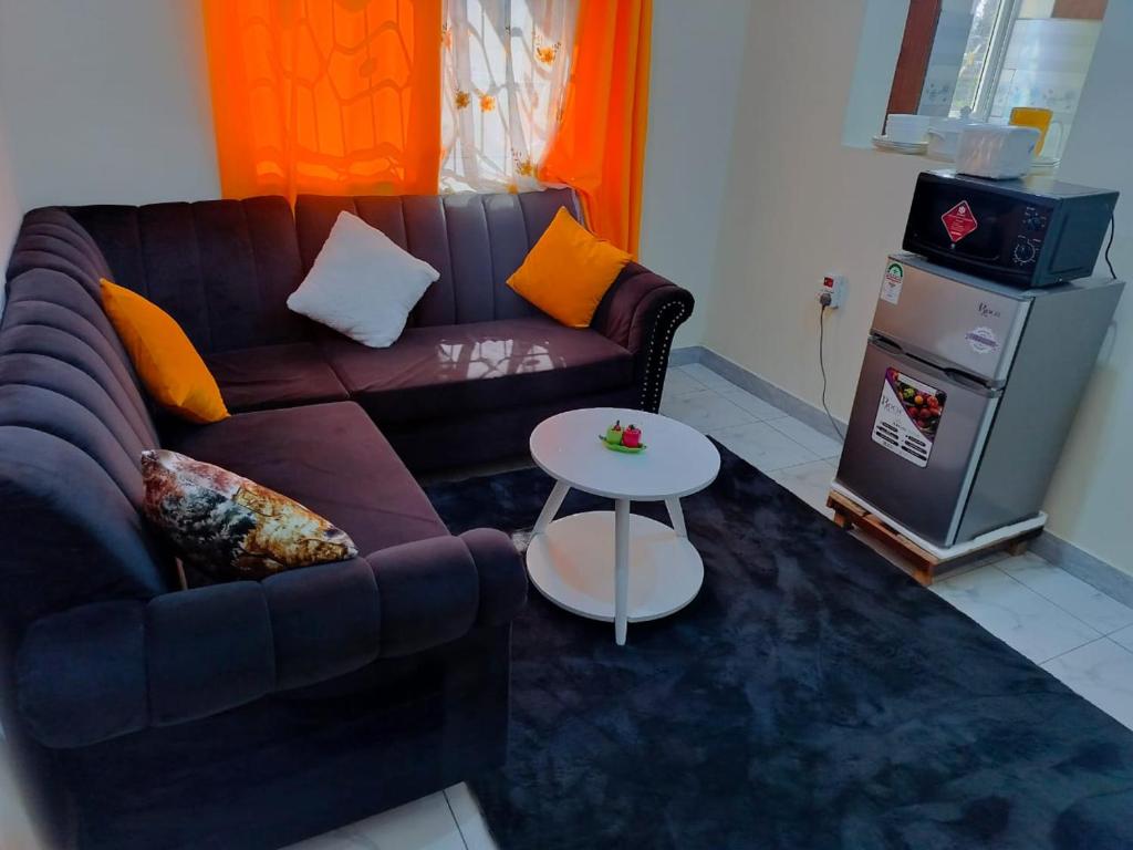 een woonkamer met een bank en een tafel bij Mwangaza in Mombasa