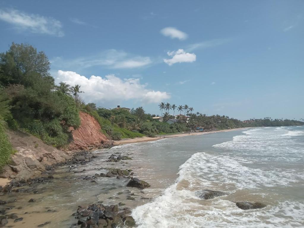 a view of a beach with waves crashing on the shore at The Ocean Villa in Matara