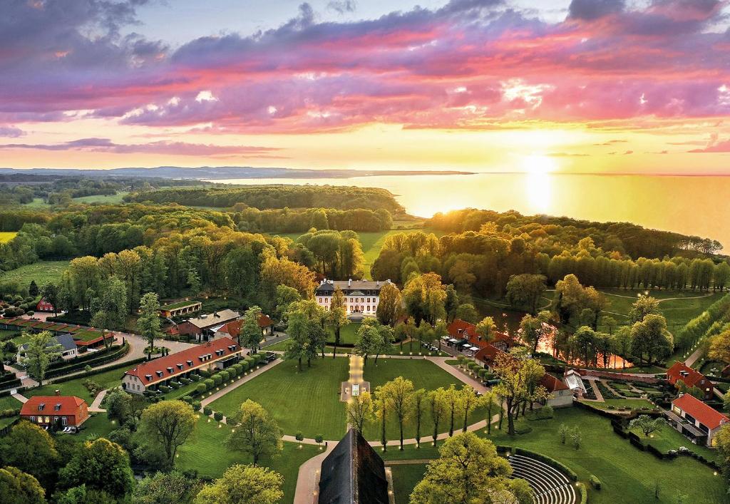 Una vista aérea de un pequeño pueblo con una puesta de sol. en Weissenhaus Private Nature Luxury Resort, en Weißenhaus