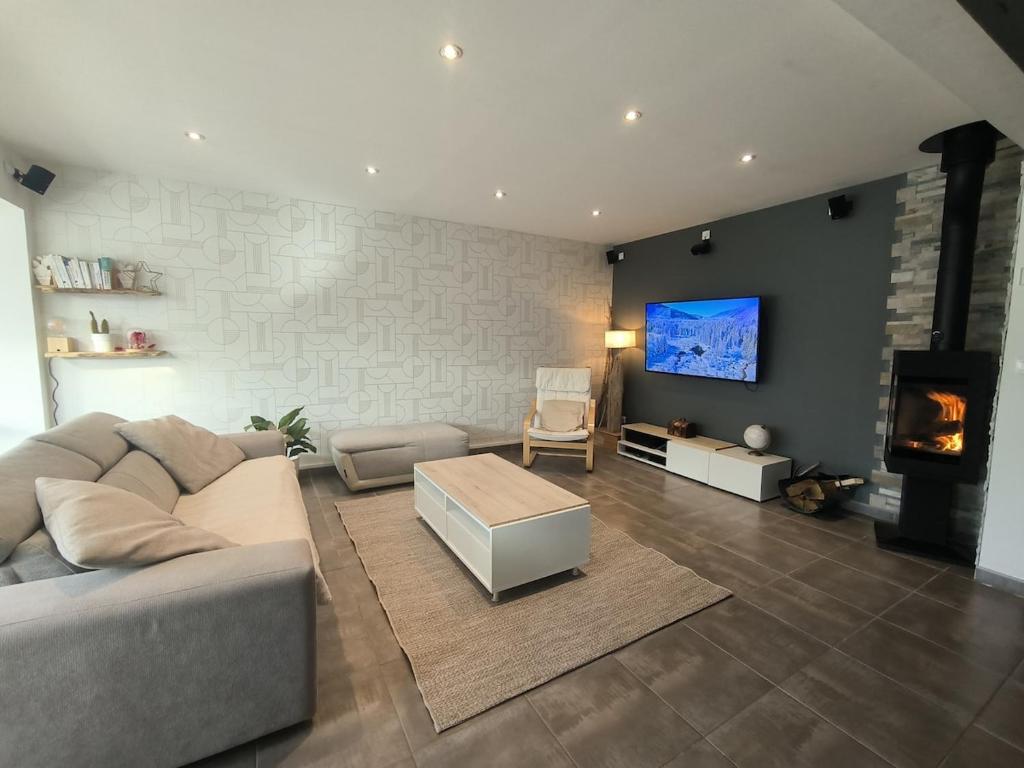 L'Emeraude في سانت هيربلان: غرفة معيشة بها أريكة وجهاز تلفزيون