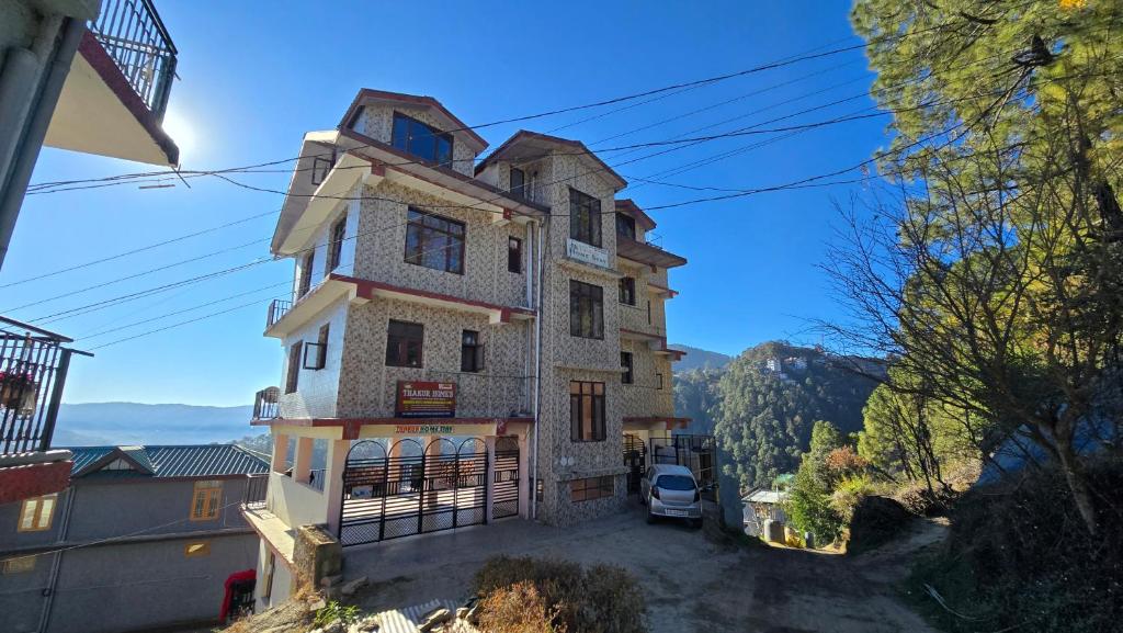 a house on a hill with a car parked in front at Thakur homes- couple and family friendly homestay in Shimla