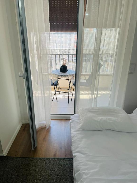 een slaapkamer met een bed en een tafel op een balkon bij Prizren Corner in Prizren
