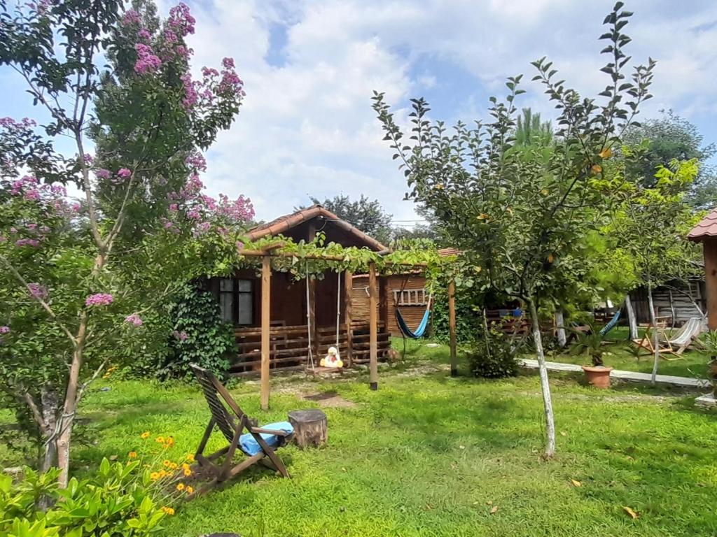 una casa con un patio con árboles y un parque infantil en Tiny houses Genacvale, en Martvili
