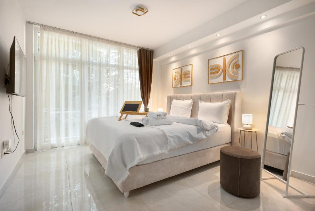 Luxury Kingbed Studio - Estia Premium Apartments في سلانيك: غرفة نوم بسرير كبير وعليها لاب توب