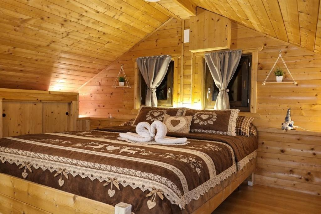 Un dormitorio con una cama en una cabaña de troncos en Maso Patrizia - Il tuo rifugio nella natura, en Pieve Tesino