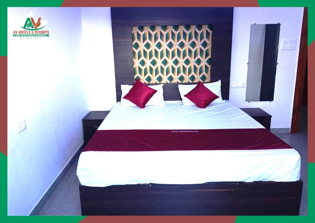 a bedroom with a large bed with red pillows at Darwar Palace By Av Hotel in Bihār Sharīf