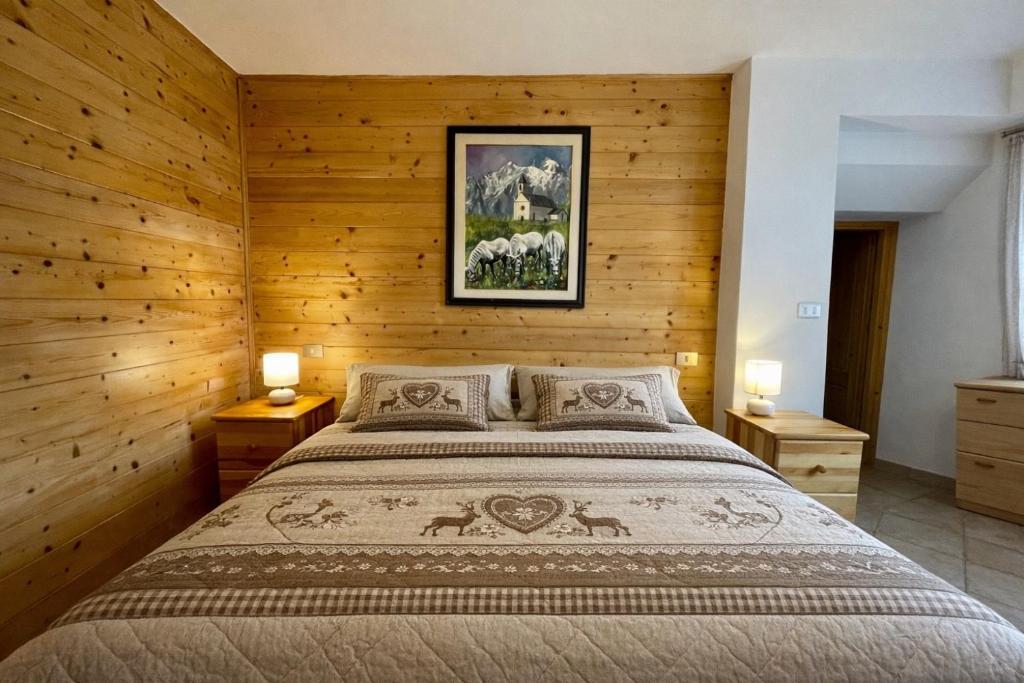 een slaapkamer met een groot bed en houten wanden bij Maso Patrizia - Rifugio caldo tra le vette in Pieve Tesino