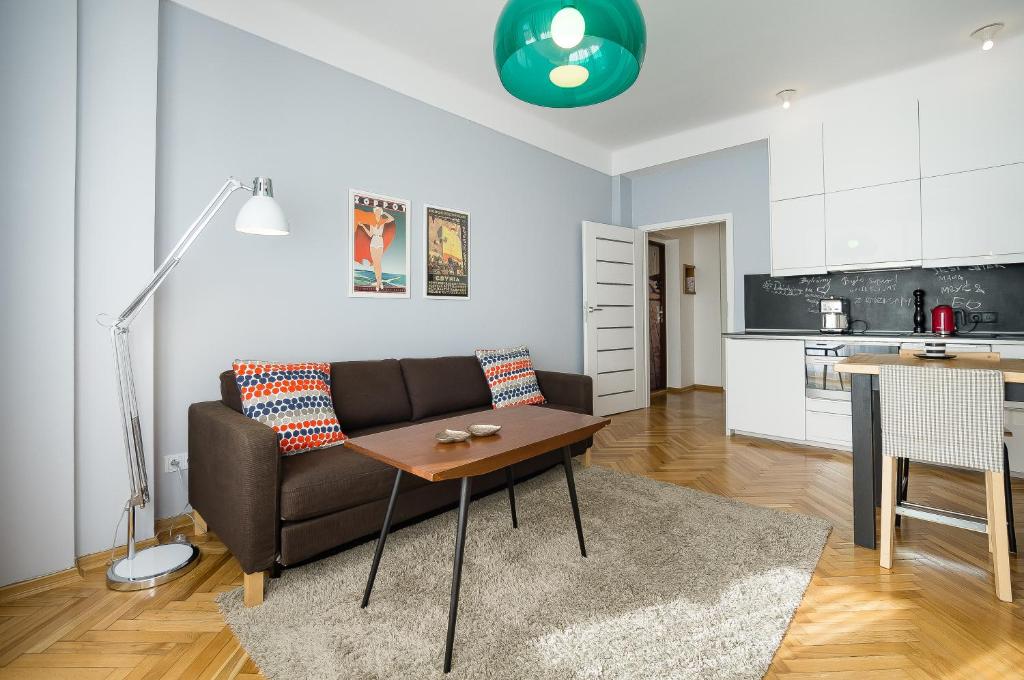 ein Wohnzimmer mit einem Sofa und einem Tisch in der Unterkunft SmileApartment Partyzantów in Gdynia