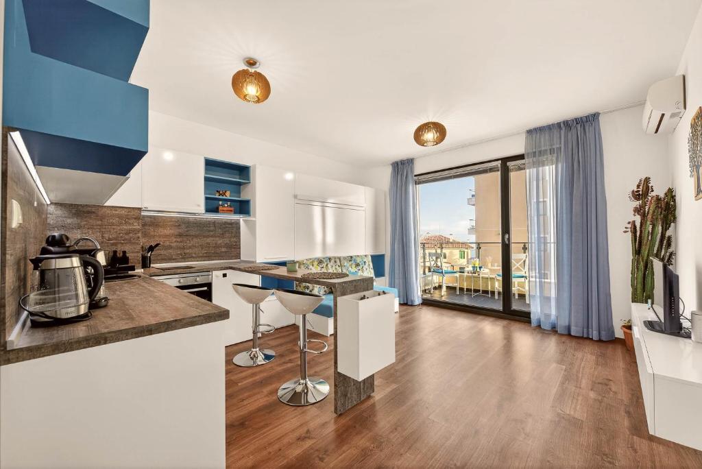 a kitchen with blue and white walls and wood floors at Didi`s Stylish Studio - Seaview & Pool Backyard in Varna City