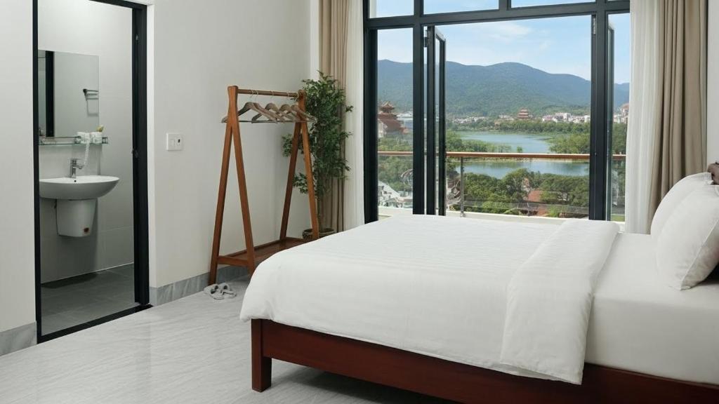 Un dormitorio con una cama y una ventana con vistas. en Trang an Apartment, en Kon Rung (1)