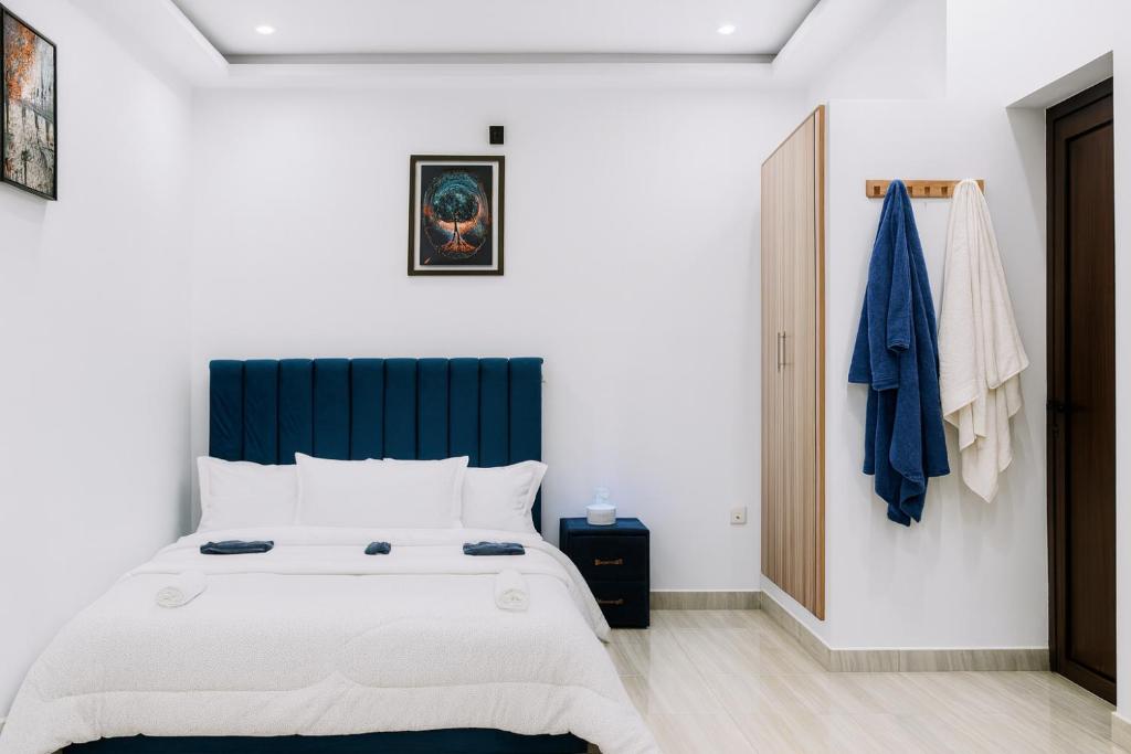 ein Schlafzimmer mit einem großen Bett mit blauem Kopfteil in der Unterkunft Bmb house in Abidjan