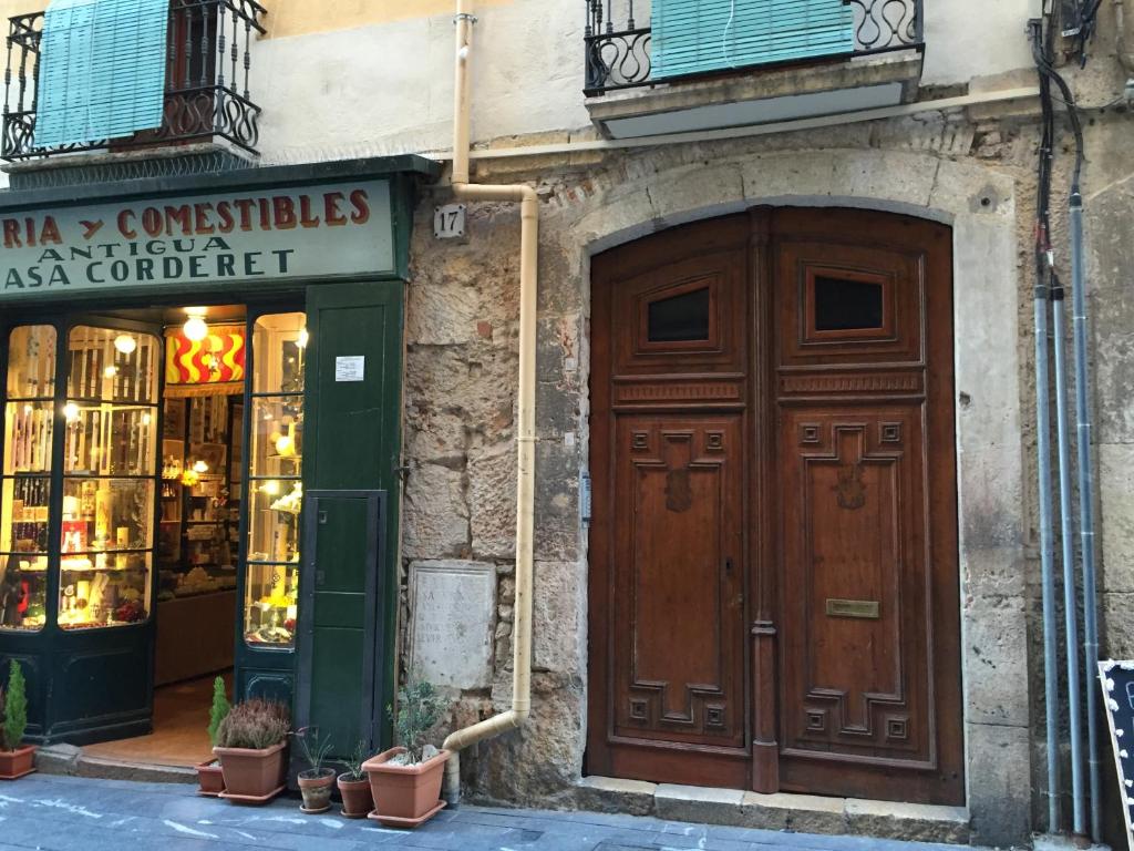 un edificio con una gran puerta de madera frente a una tienda en Apartamento Merceria - Tarragona, en Tarragona