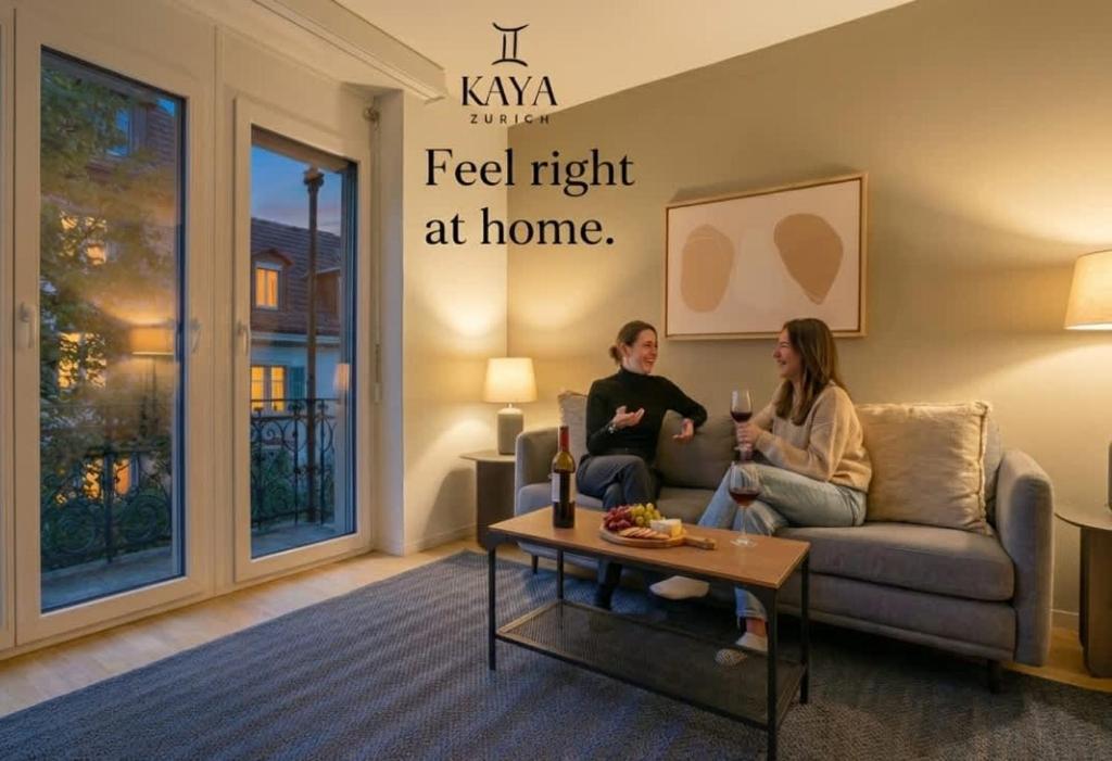 twee mensen zitten op een bank in een woonkamer bij KAYA Zurich Apartment PARAIBA- Downtown Deluxe 2BR Apt in Zürich