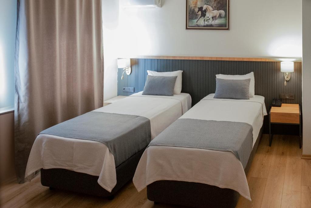 two beds in a hotel room withermottermottermott at Grand Keskin Otel in Denizli
