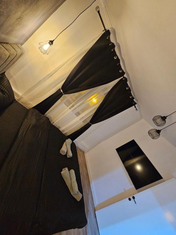 una camera da letto con un letto con un piumone nero di Promenada mall side a Craiova