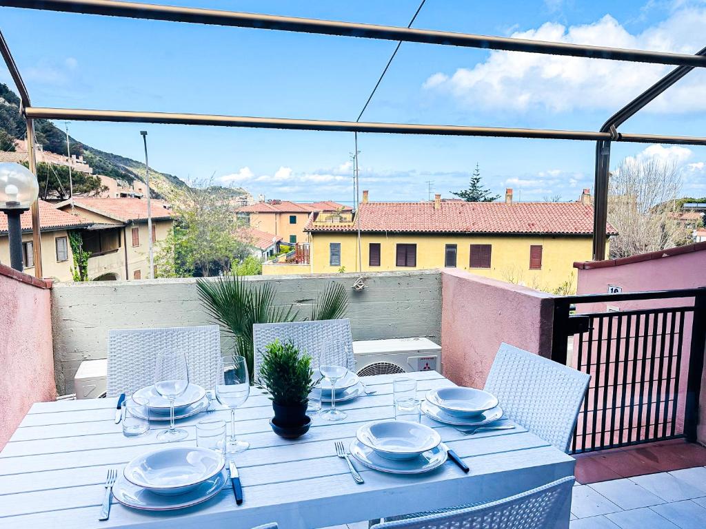 een witte tafel met borden en keukengerei op een balkon bij Alberto in Campese