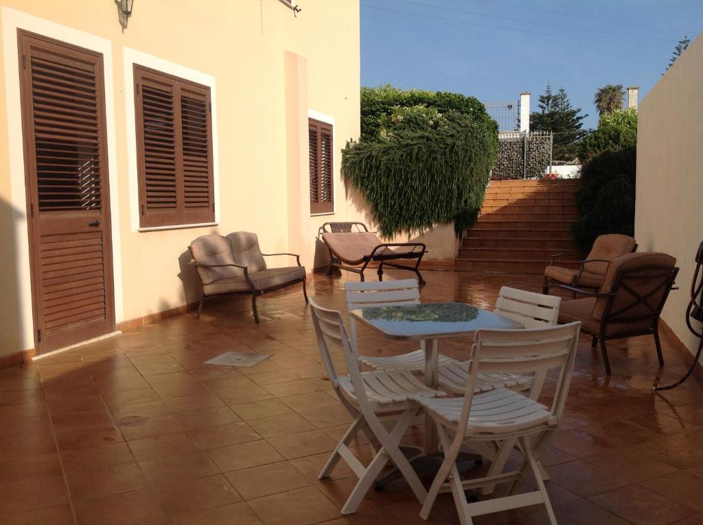 a patio with chairs and a table and chairs at A Due Passi Dal Mare in Petrosino