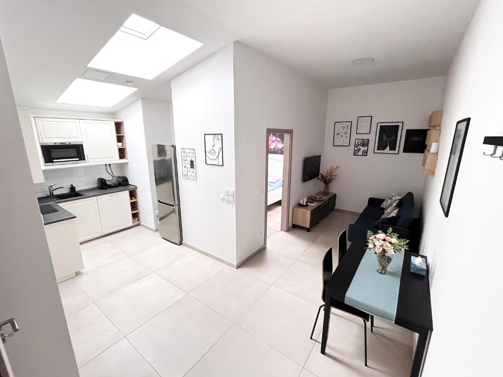 a kitchen and a living room with a table and chairs at CDP Apartmanok in Alsóörs