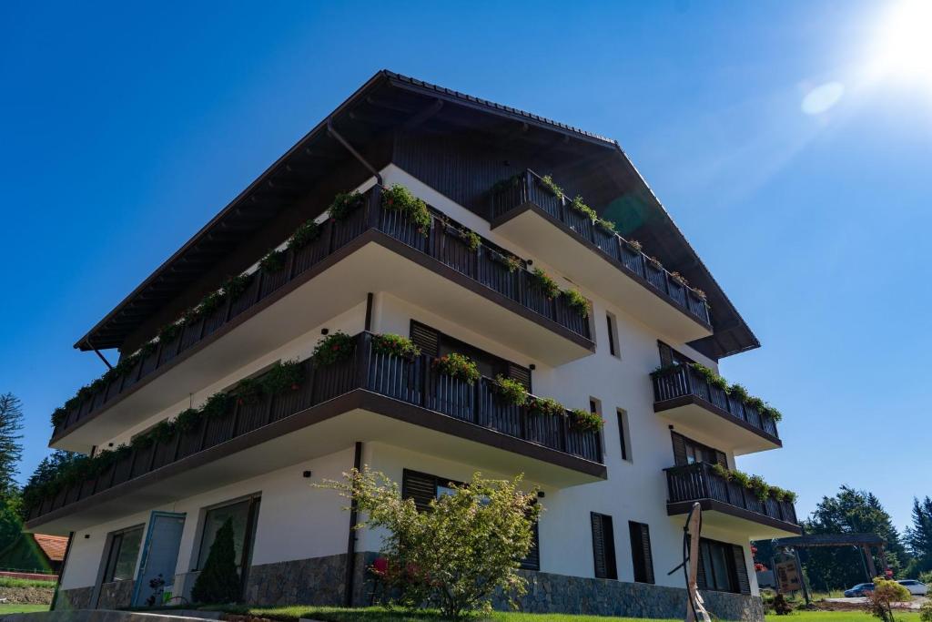 a building with balconies and plants on it at Grand Chalet Ramina in Poiana Brasov