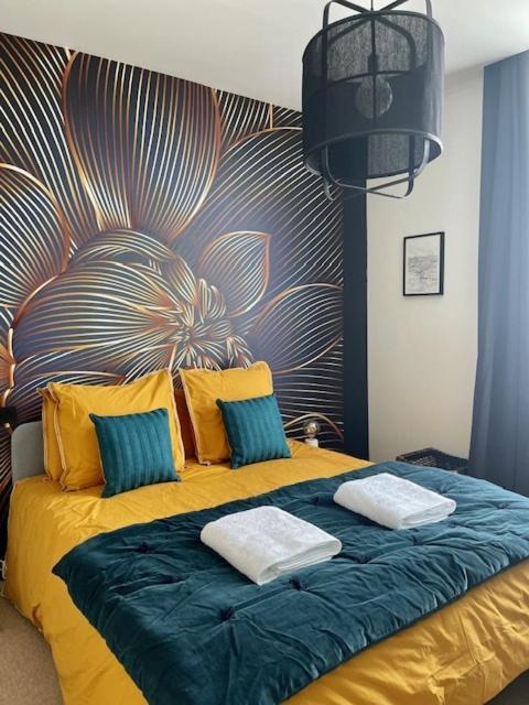 a bed with two pillows on it in a room at Maison Le Beaulieu in Vichy