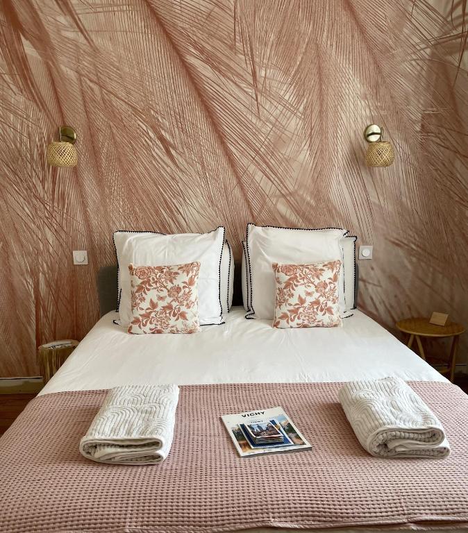 维希MAISON LE BEAULIEU的一张带两条毛巾的床和杂志