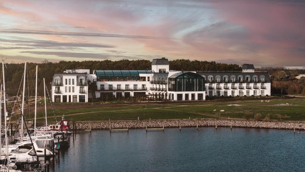 a large building next to a marina with boats in the water at Rox Resort in Køge