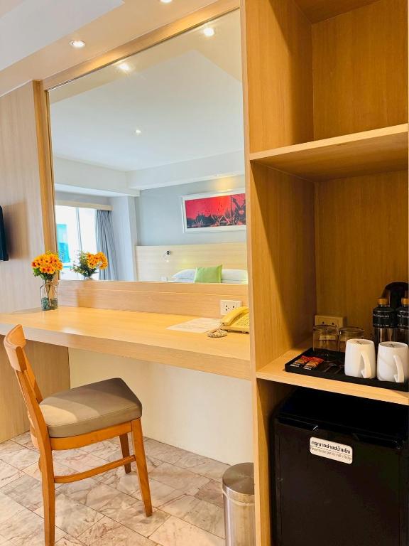 A built-in vanity desk beside a beverage station and compact refrigerator.