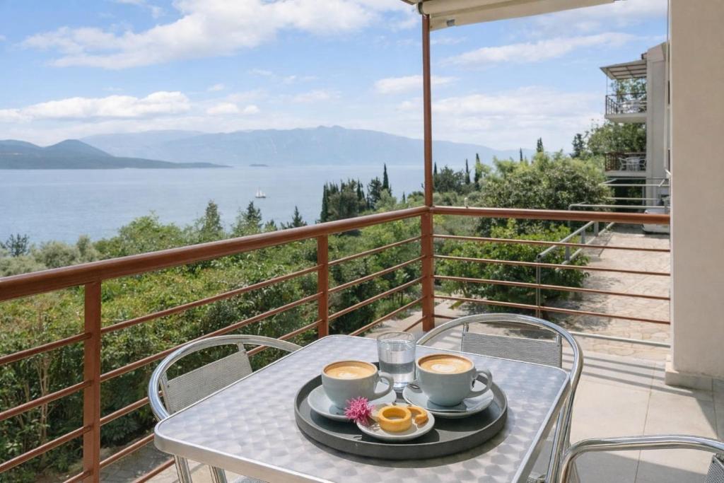 een tafel met twee kopjes koffie op een balkon bij Miranda Resort in Nikiana