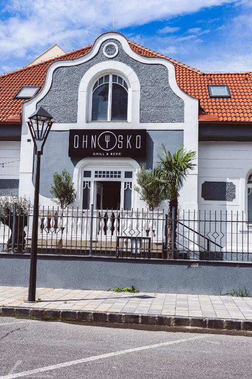a building with a sign on the side of a street at Penzion Ohnysko in Trnava