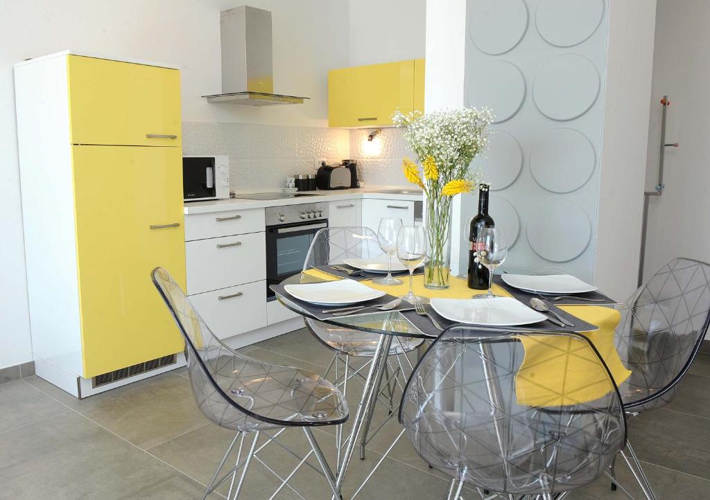 a kitchen with a table with chairs and a yellow refrigerator at Apartment Livingstone in Rijeka